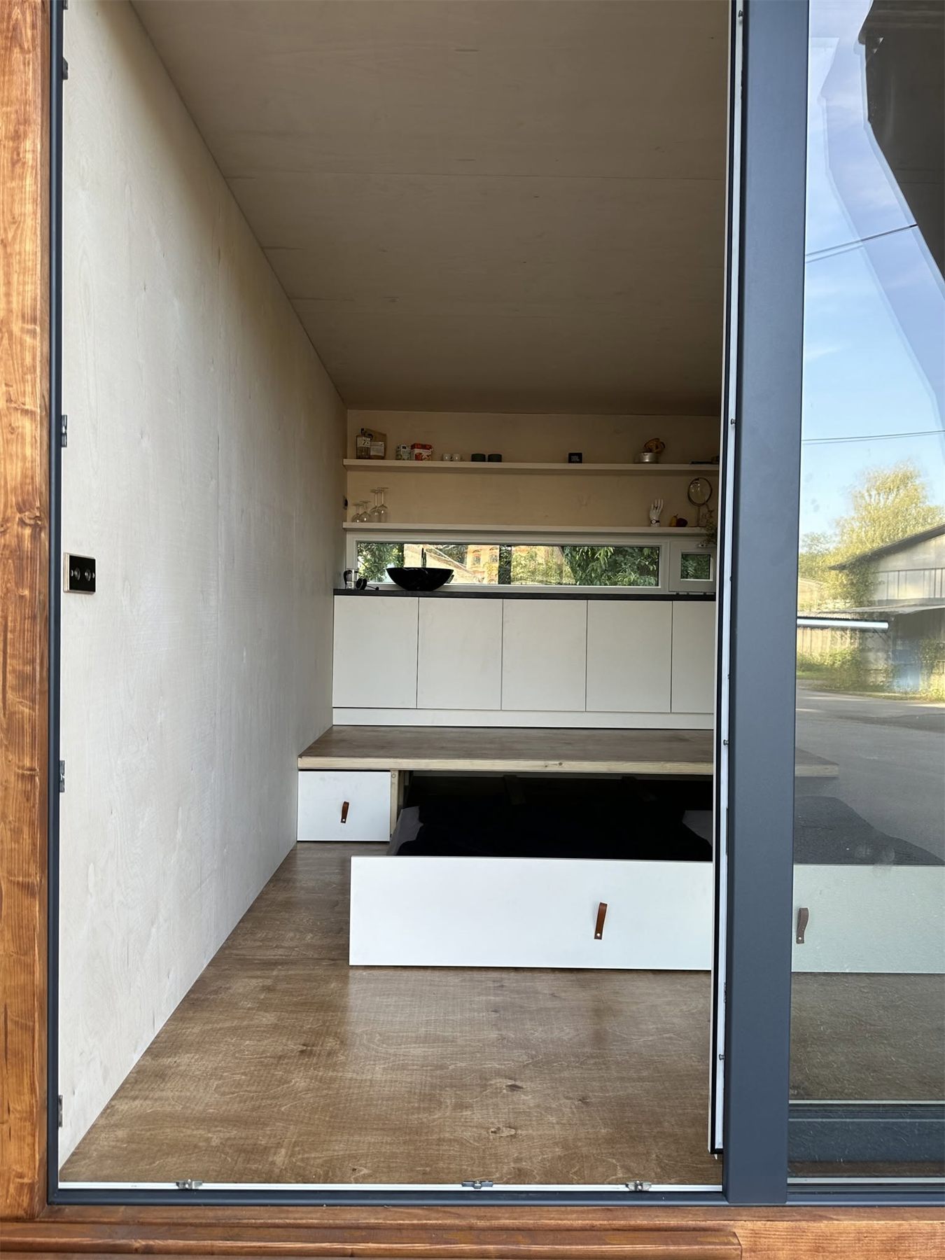 Interiér tiny house s vysunutým úložným prostorem