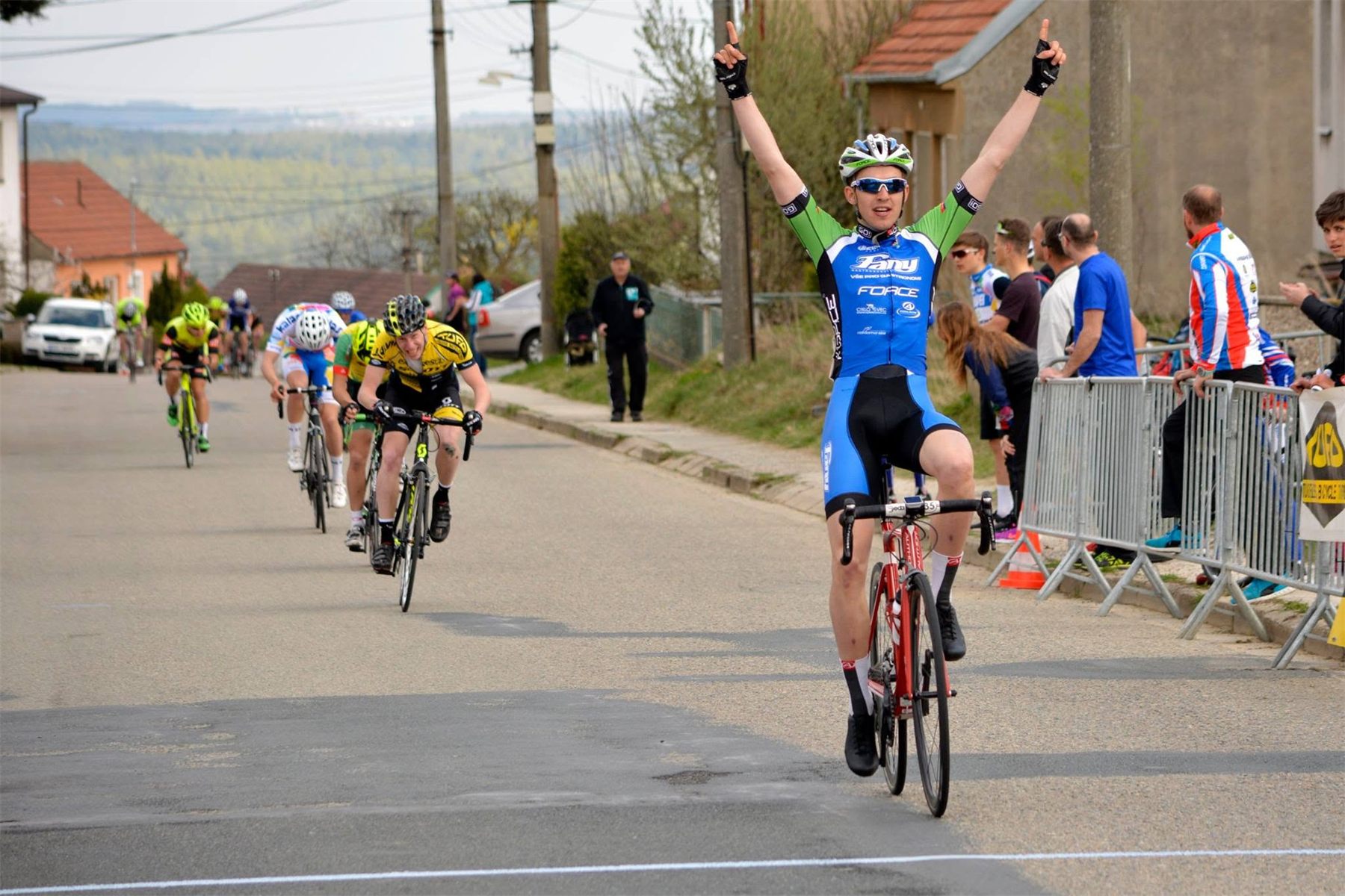 Cyklista se zdviženýma rukama v cíli závodu