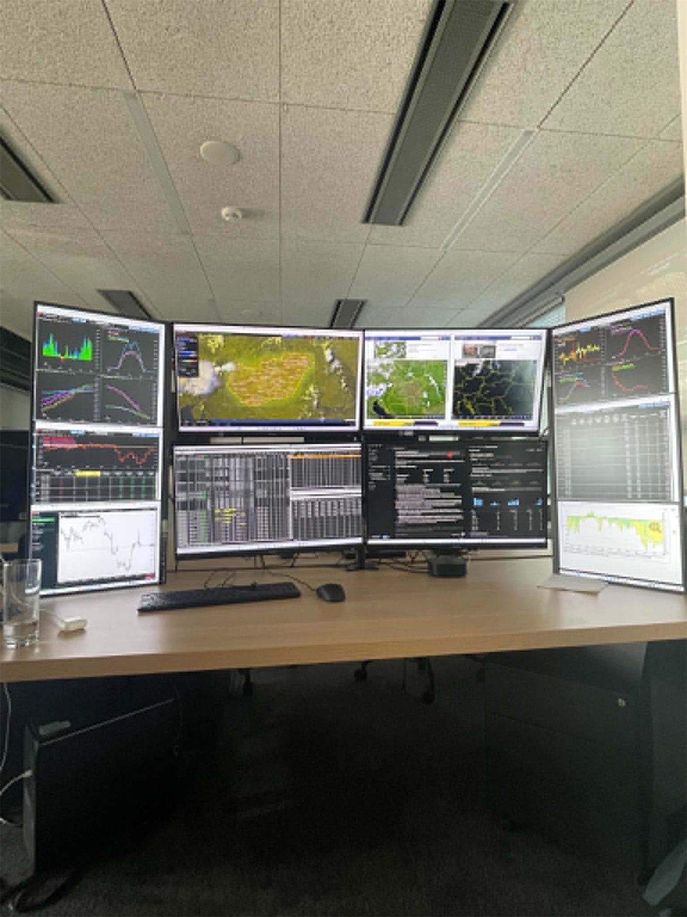 Tradingové pracoviště s grafy a meteorologickými daty na monitorech